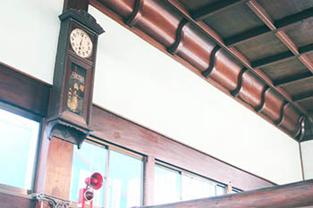 「梅乃湯さん江」と書かれた大きな柱時計の写真